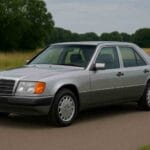 Mercedes W124 E 320 sedan in zilver, gezien van de zijkant, klassieke tijdloze styling.